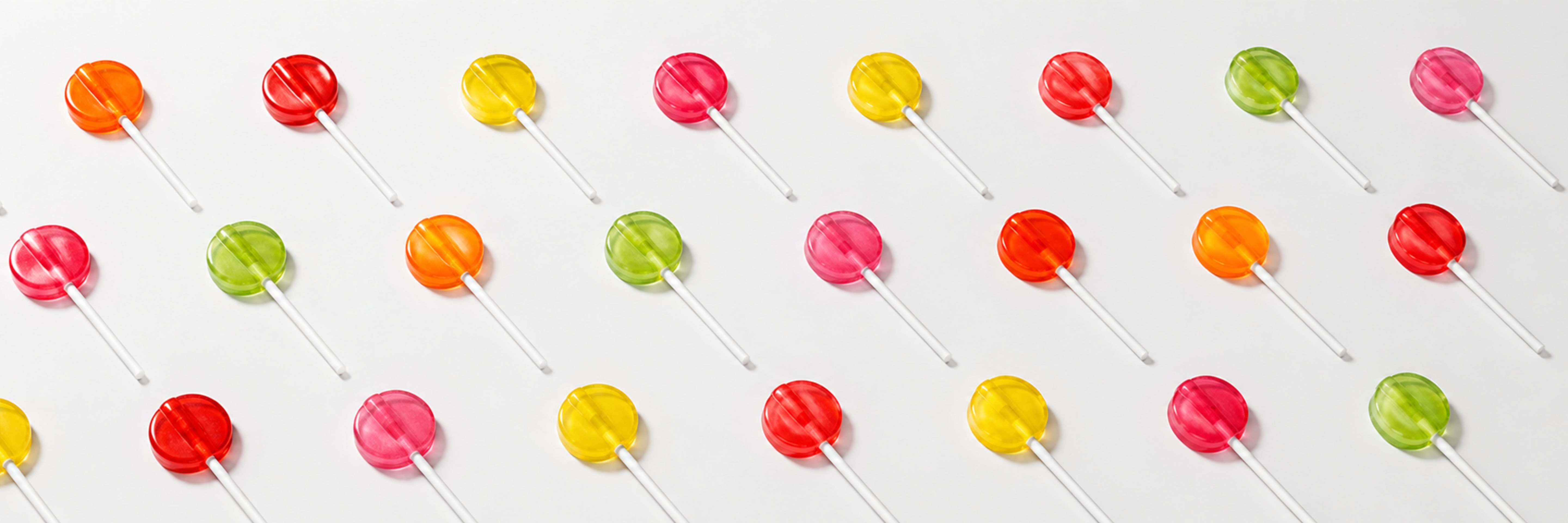 Colourful flat lollipops arranged diagonally - Makson Healthcare lollipop manufacturing
